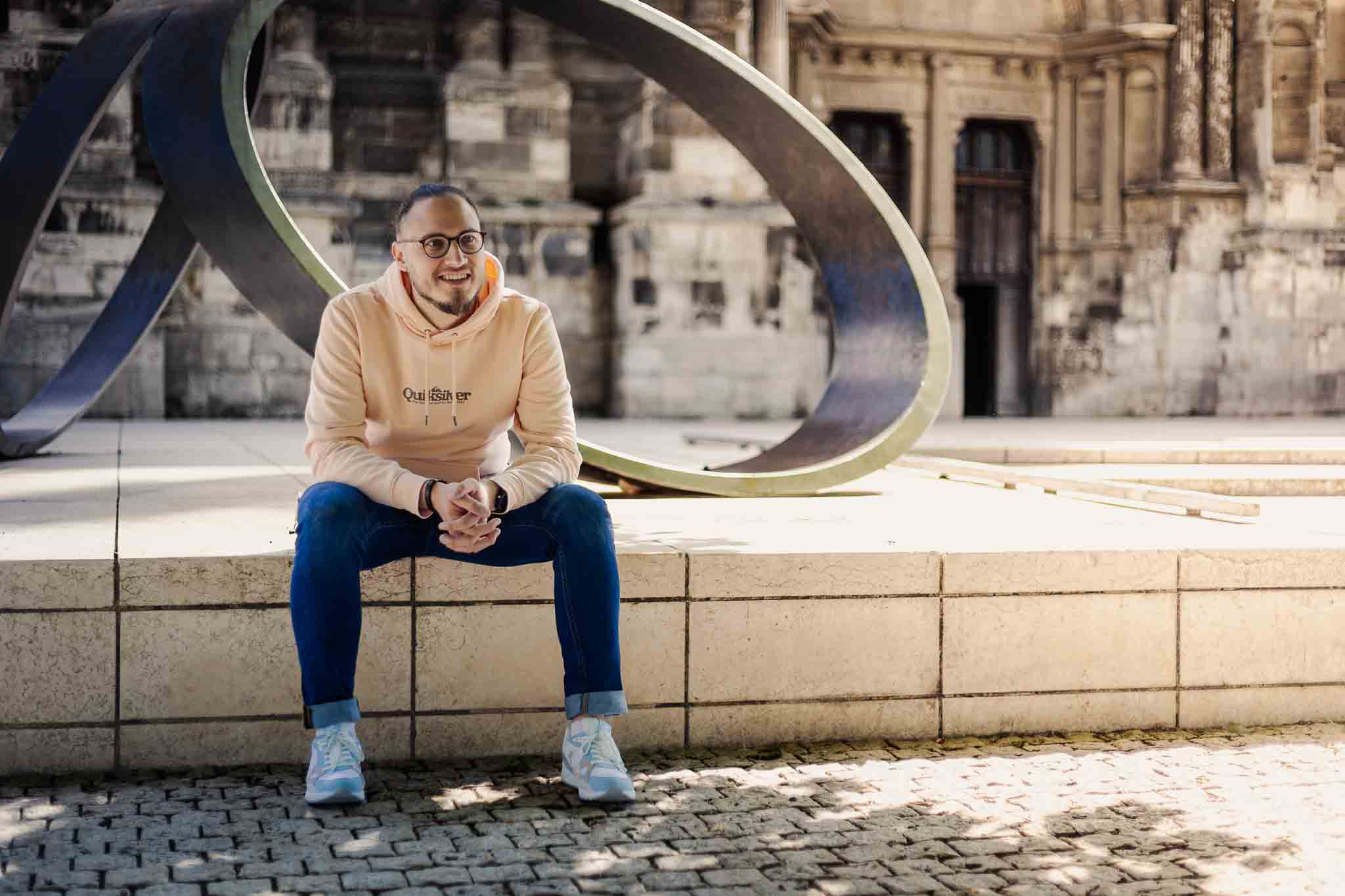 Portrait souriant devant la sculpture emblématique d’Évreux – Shooting confiance en soi