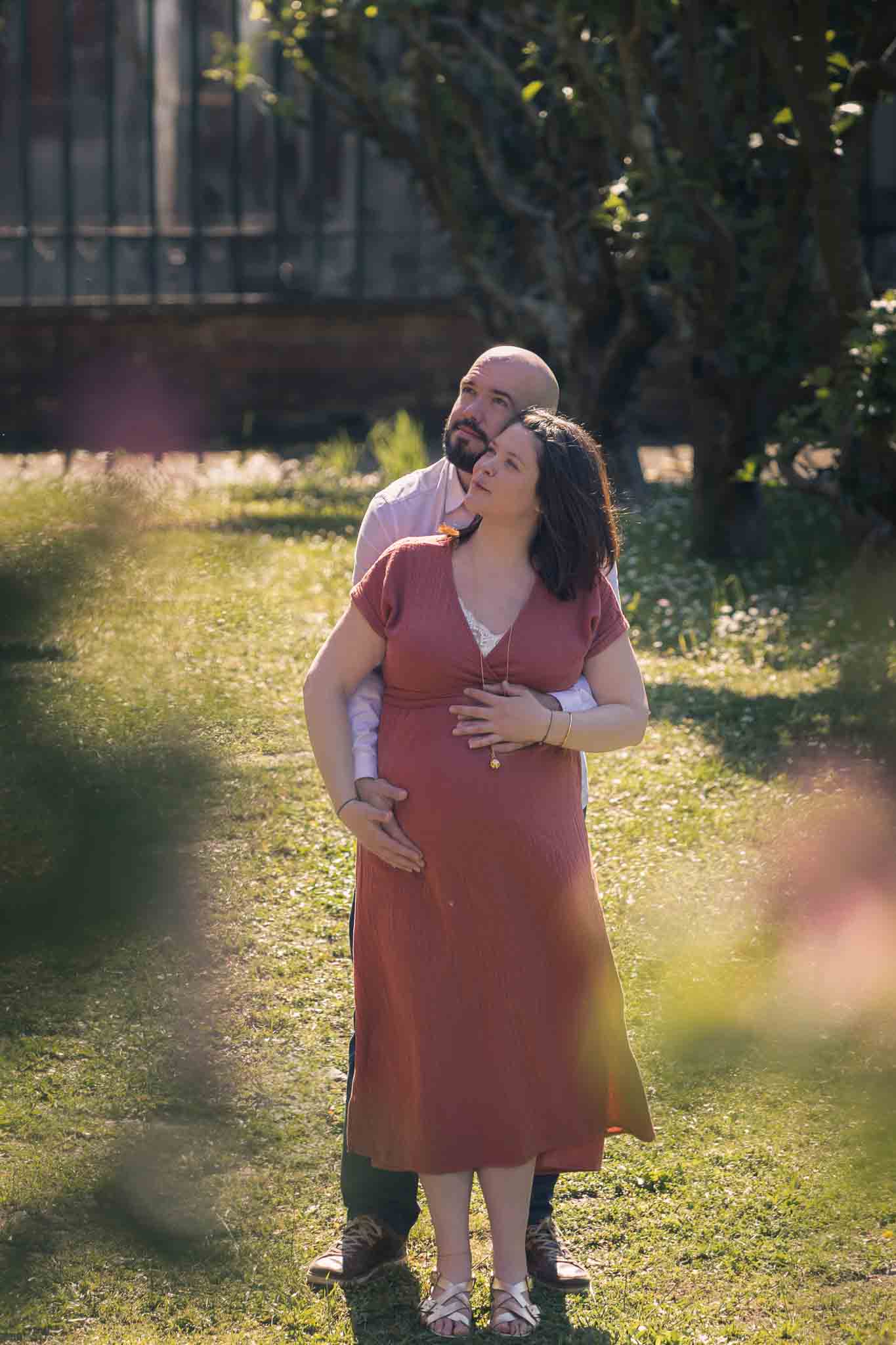 Séance photo grossesse à Évreux – Portrait poétique en couleurs, des futurs parents s’enlaçant en Normandie